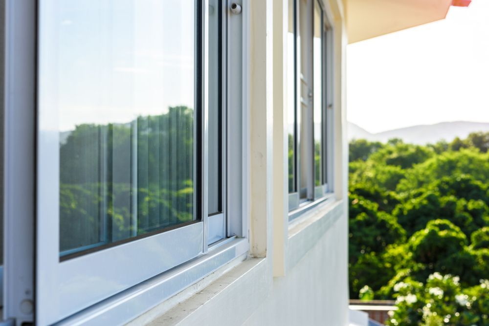 Open White Window Overlooking Green Trees and Distant Hills on a Sunny Day — ALUBEST Windows & Doors In Southport, QLD