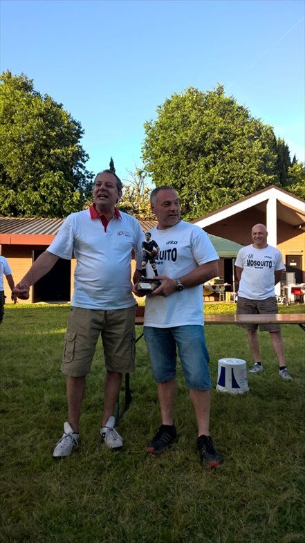 Due uomini sono in piedi in un campo erboso e tengono in mano un trofeo.