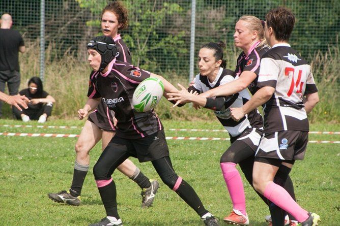 Un gruppo di ragazze sta giocando a rugby su un campo.
