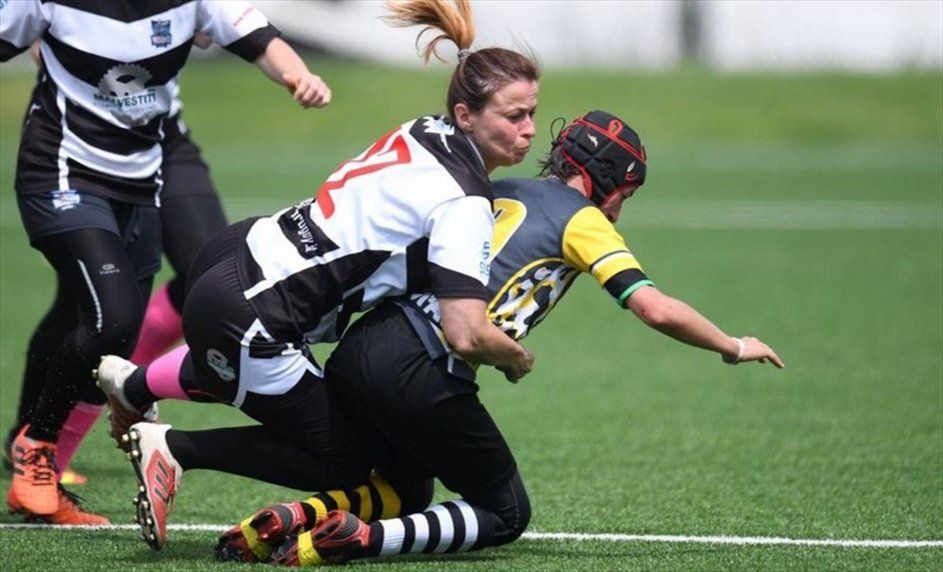 Un gruppo di donne sta giocando a rugby su un campo.