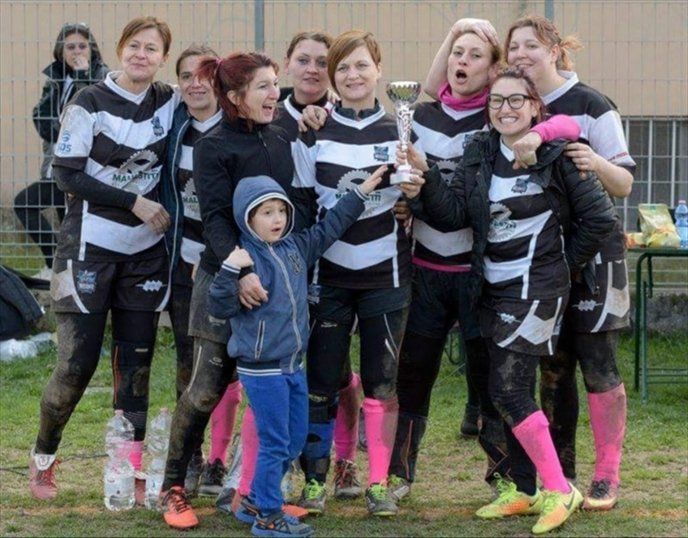 Un gruppo di donne posa per una foto mentre reggono un trofeo.