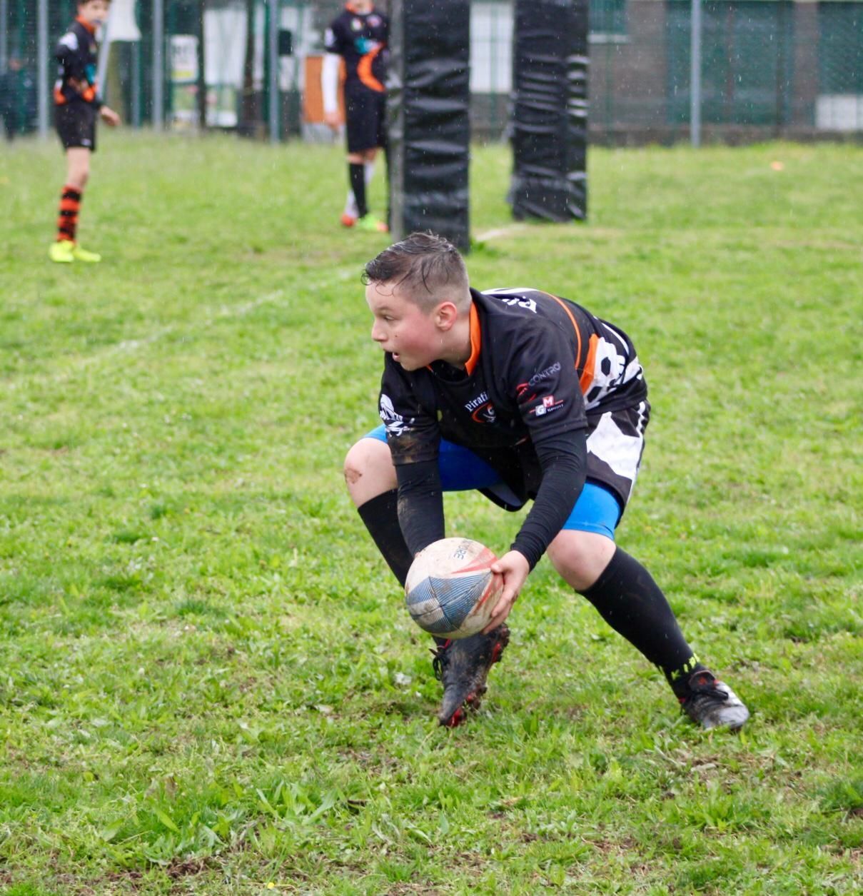 Un ragazzino sta giocando a rugby su un campo erboso