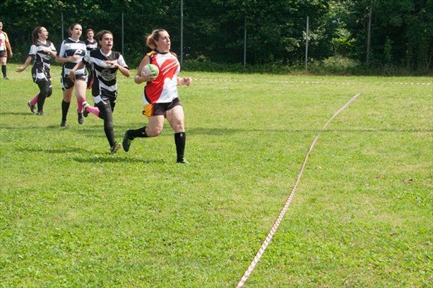 Un gruppo di ragazze sta giocando a rugby su un campo.