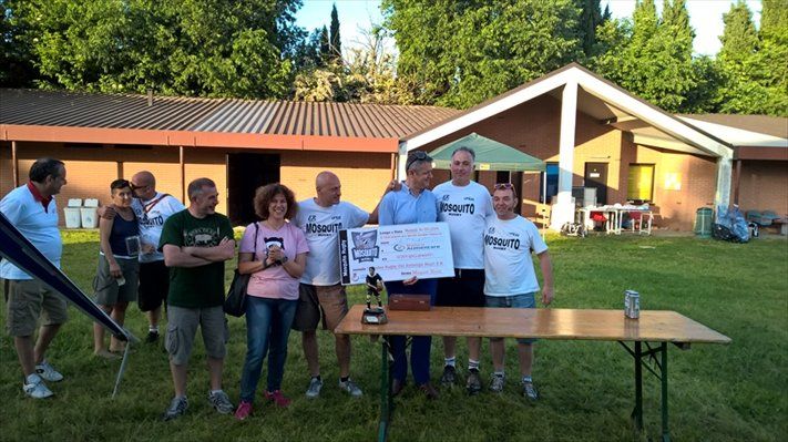 Un gruppo di persone in piedi attorno a un tavolo che tengono in mano un assegno di grande entità.
