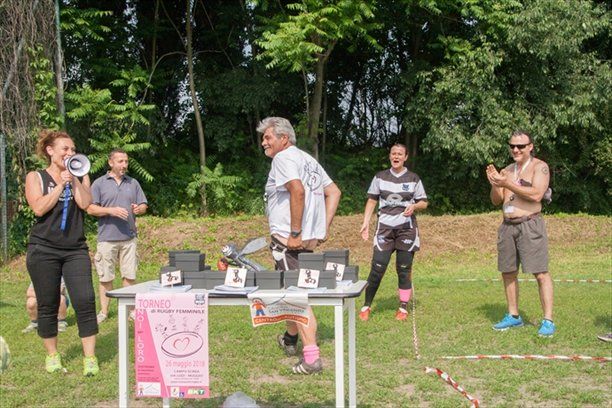 Un gruppo di persone è in piedi attorno a un tavolo in un campo.