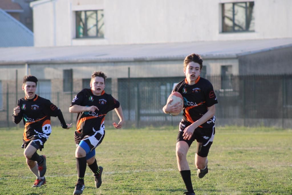 Un gruppo di giovani uomini sta giocando a rugby su un campo.