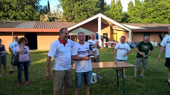Un uomo con una camicia da martini tiene in mano un trofeo