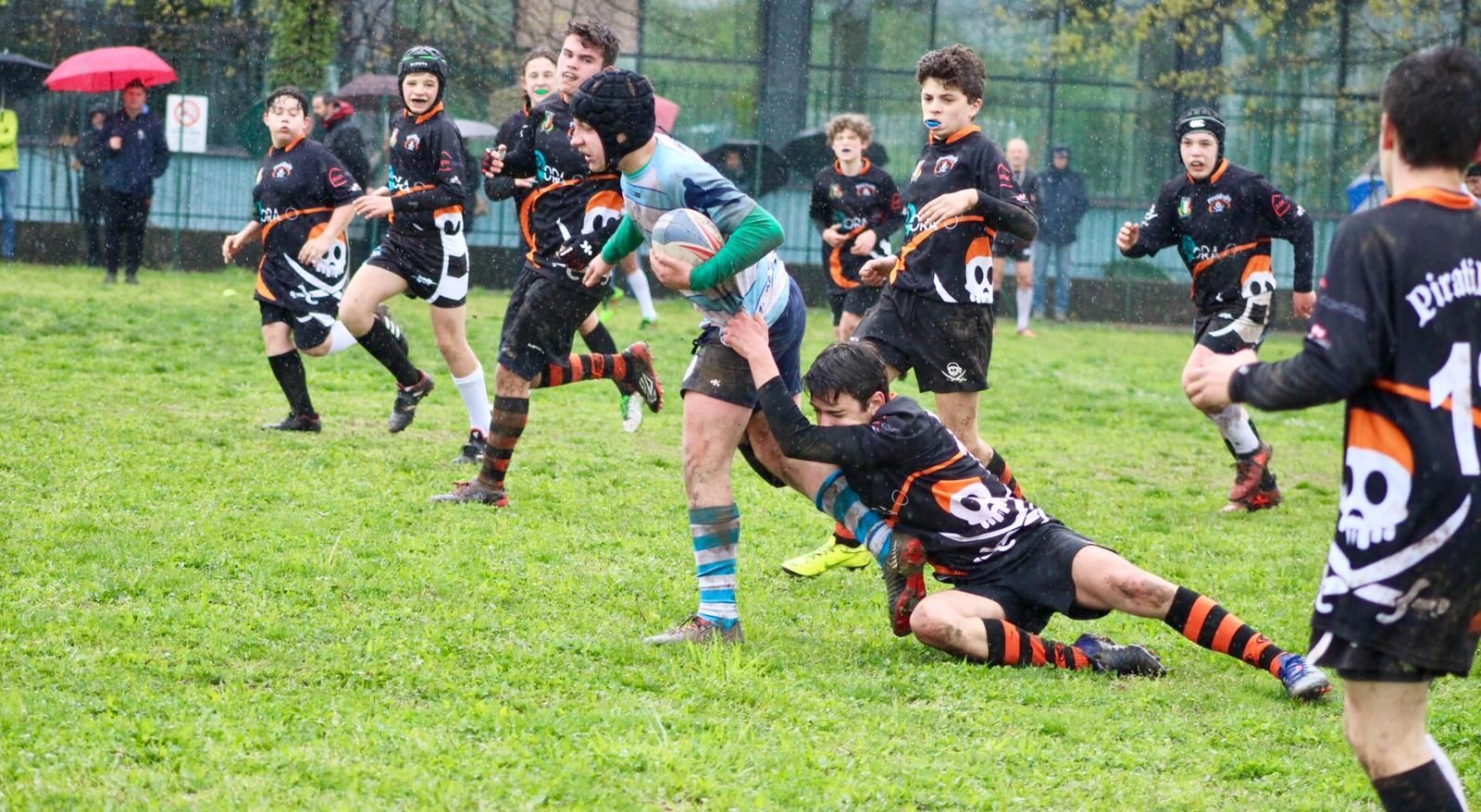 Un gruppo di ragazzi sta giocando a rugby su un campo.