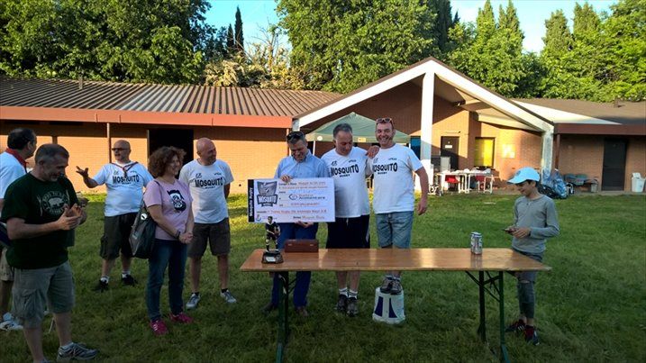Un gruppo di persone in piedi attorno a un tavolo davanti a una casa.