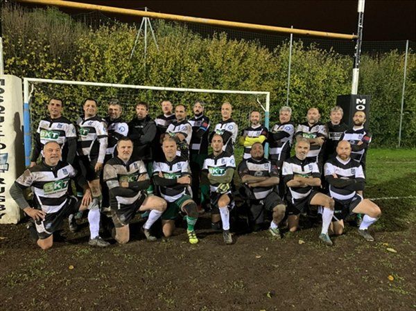 Un gruppo di uomini posa per una foto su un campo da calcio.