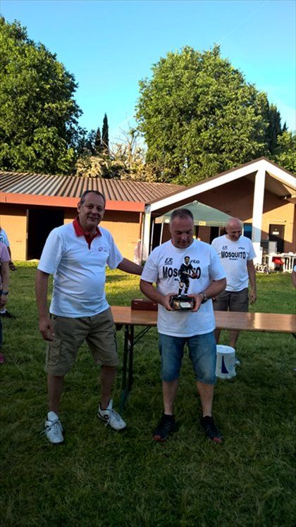 Due uomini sono in piedi in un campo erboso e tengono in mano un trofeo.