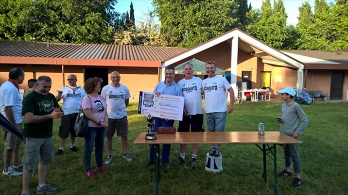 Un gruppo di persone è in piedi attorno a un tavolo e tiene in mano un assegno di grossa entità.