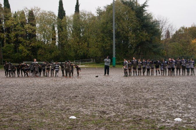 Un gruppo di persone è in piedi in un campo fangoso.