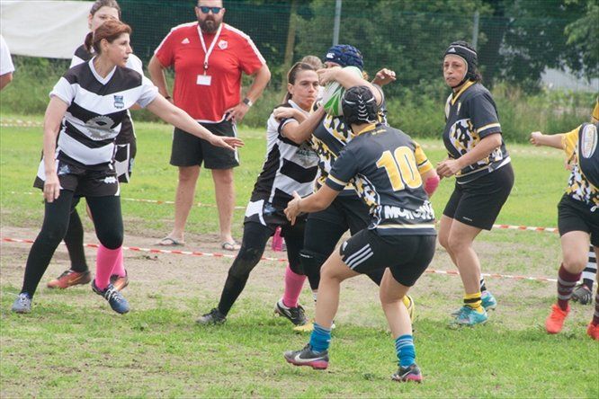 Un gruppo di donne sta giocando a rugby e una di loro ha il numero 10 sulla maglia