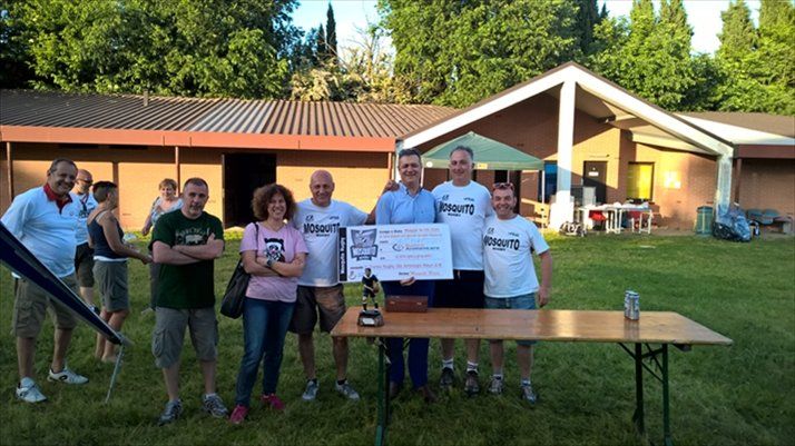 Un gruppo di persone in piedi attorno a un tavolo che tiene in mano un assegno di grandi dimensioni