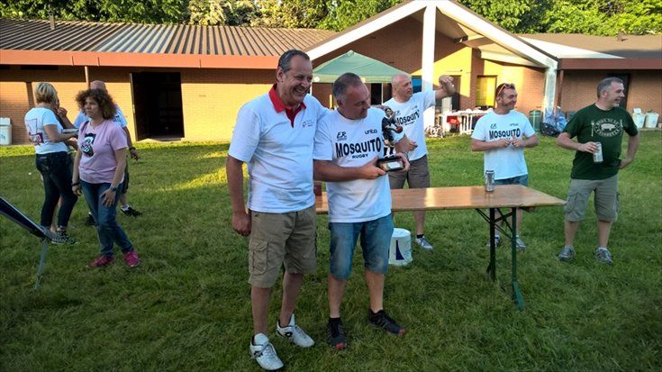 Due uomini sono in piedi uno accanto all'altro in un campo e tengono in mano un trofeo.