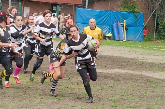 Un gruppo di persone sta giocando una partita di rugby su un campo.