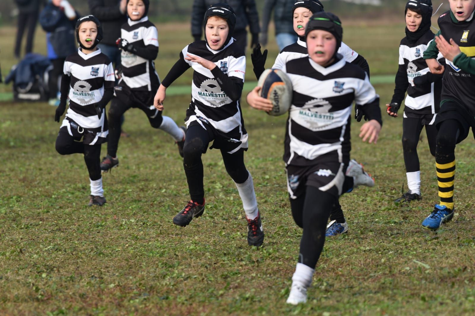 Un gruppo di ragazzi sta giocando a rugby su un campo.