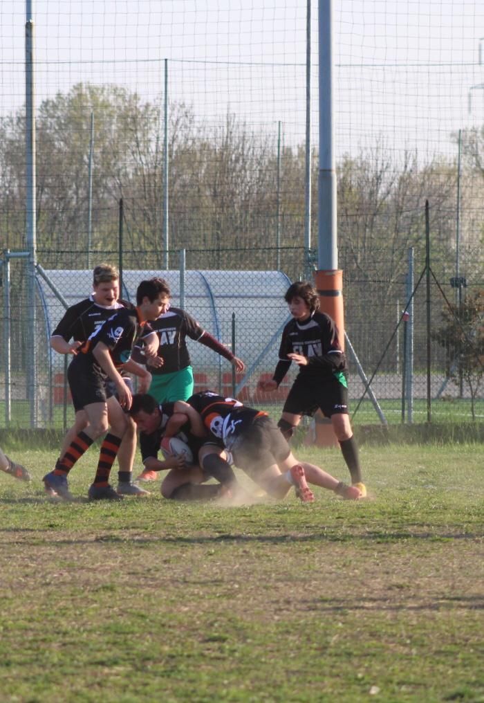 Un gruppo di ragazzi sta giocando a rugby su un campo.