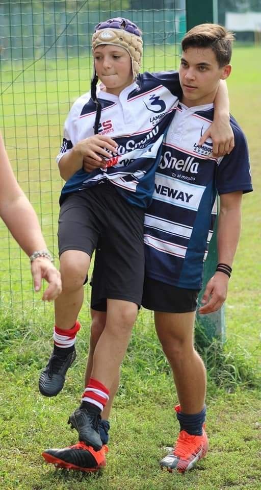 Un ragazzo porta un altro ragazzo sulle spalle su un campo da calcio.