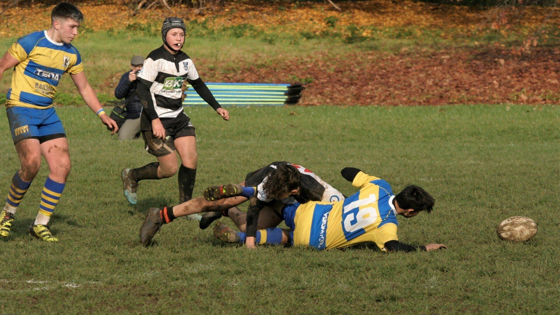 Un gruppo di giovani uomini sta giocando a rugby su un campo.
