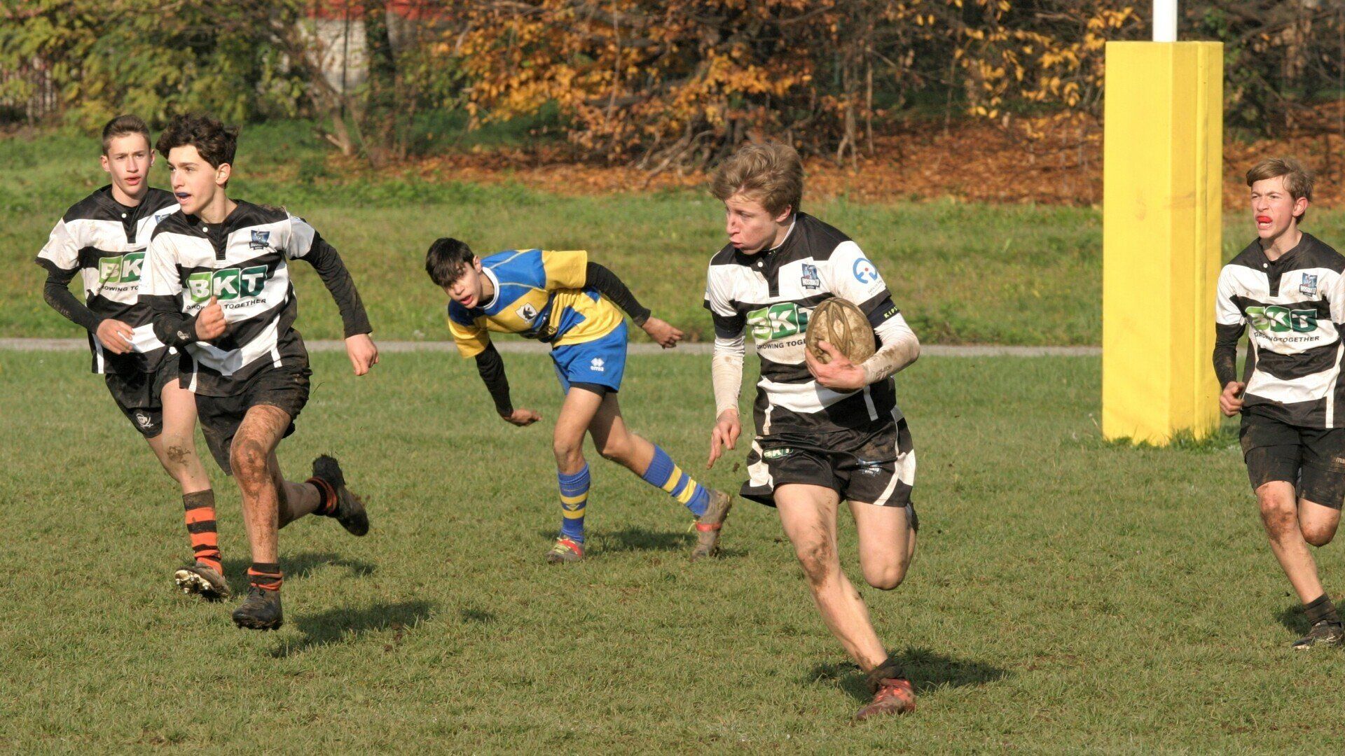 Un gruppo di giovani uomini sta giocando a rugby su un campo.