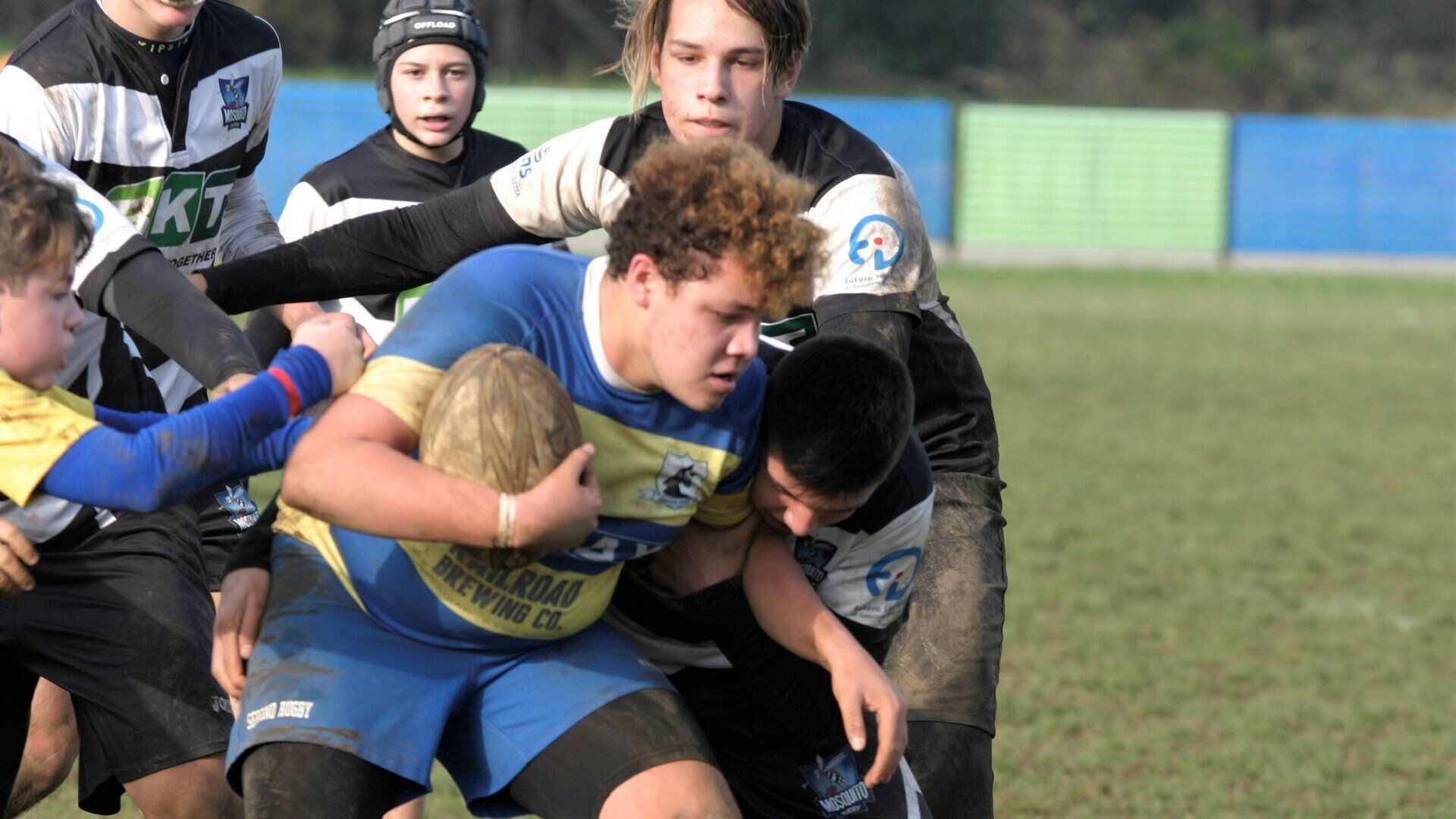 Un gruppo di giovani uomini sta giocando a rugby su un campo.