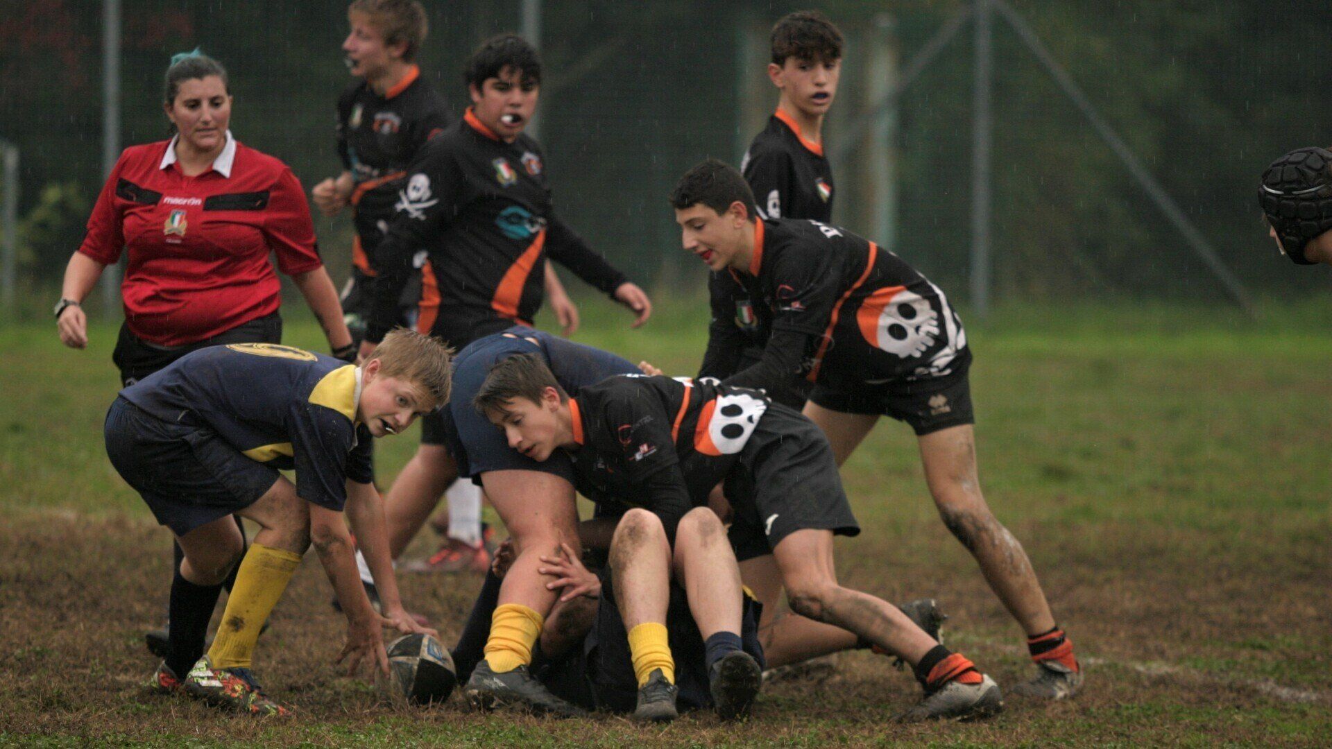 Un gruppo di giovani uomini sta giocando a rugby su un campo.