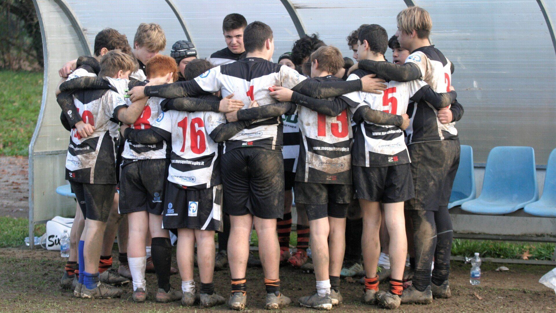 Un gruppo di ragazzi è ammassato insieme, uno dei quali indossa il numero 16