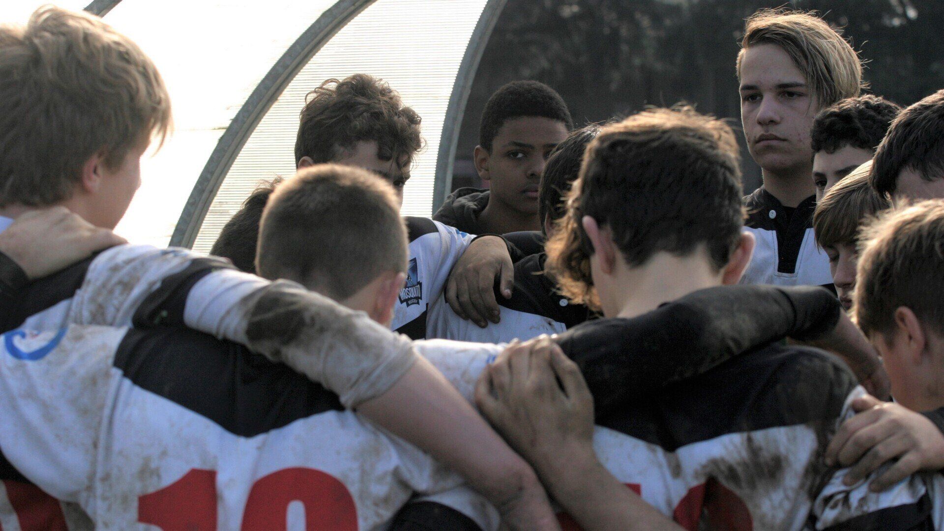 Un gruppo di ragazzi è ammassato insieme e uno di loro ha il numero 10 sulla maglietta