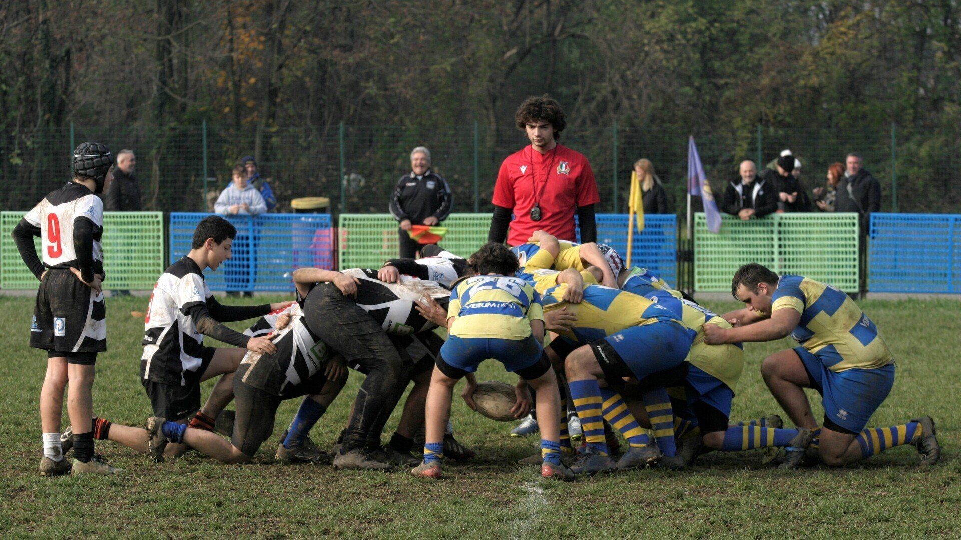 Un gruppo di giocatori di rugby sono ammassati insieme sul campo