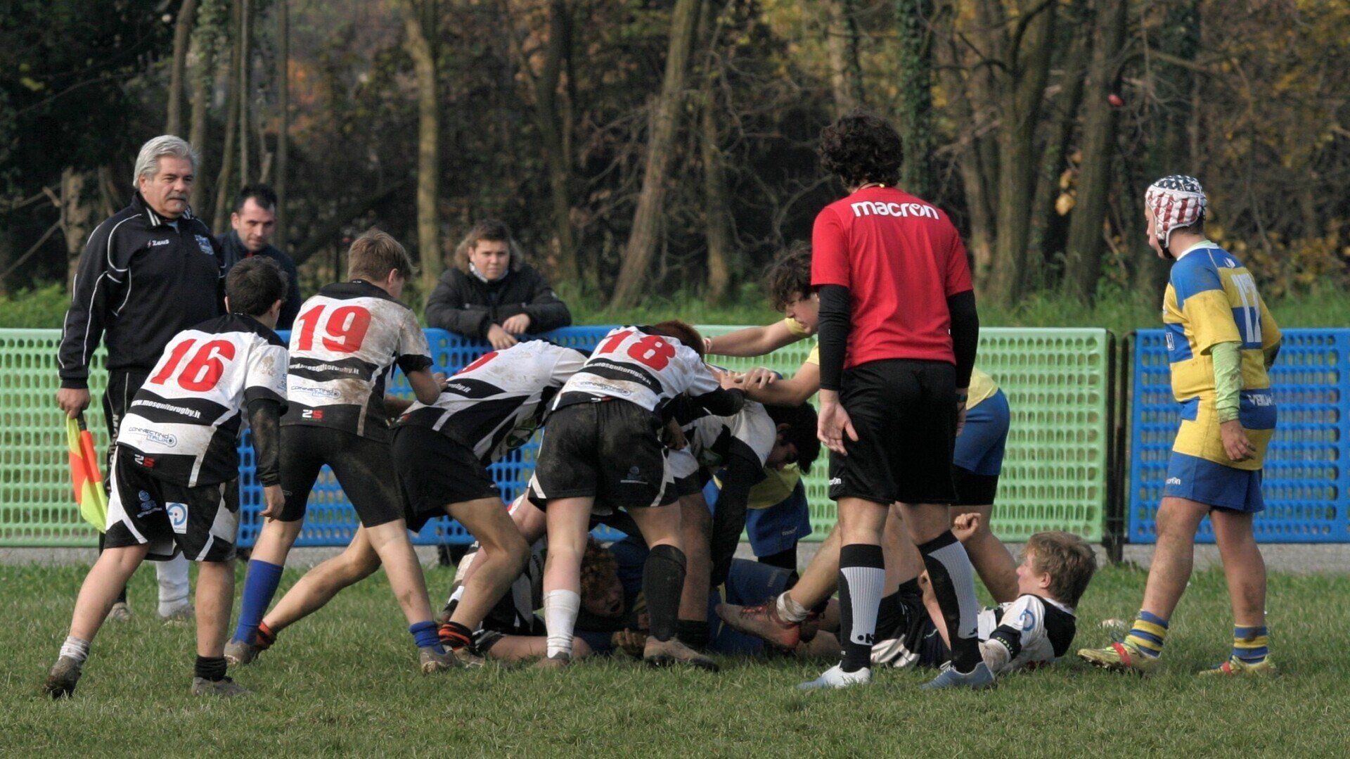 Un gruppo di ragazzi sta giocando a rugby e uno dei giocatori ha il numero 19 sulla maglia
