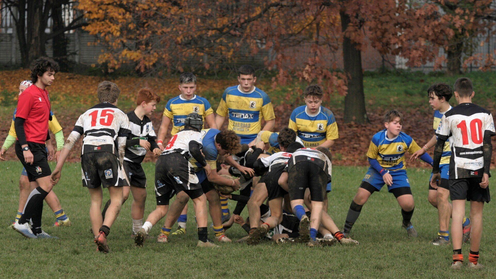 Un gruppo di ragazzi sta giocando a rugby su un campo.