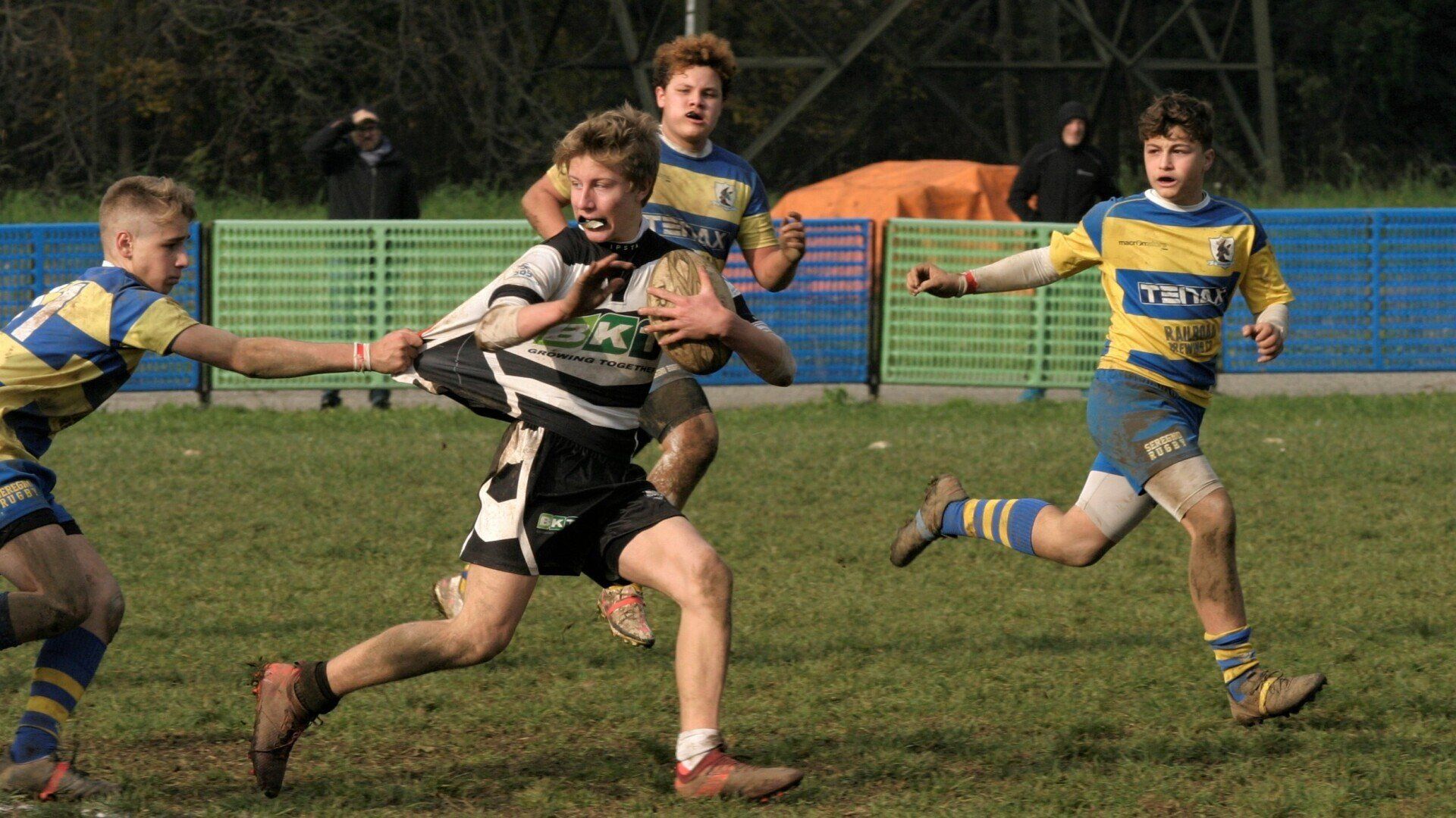 Un gruppo di ragazzi sta giocando a rugby su un campo.