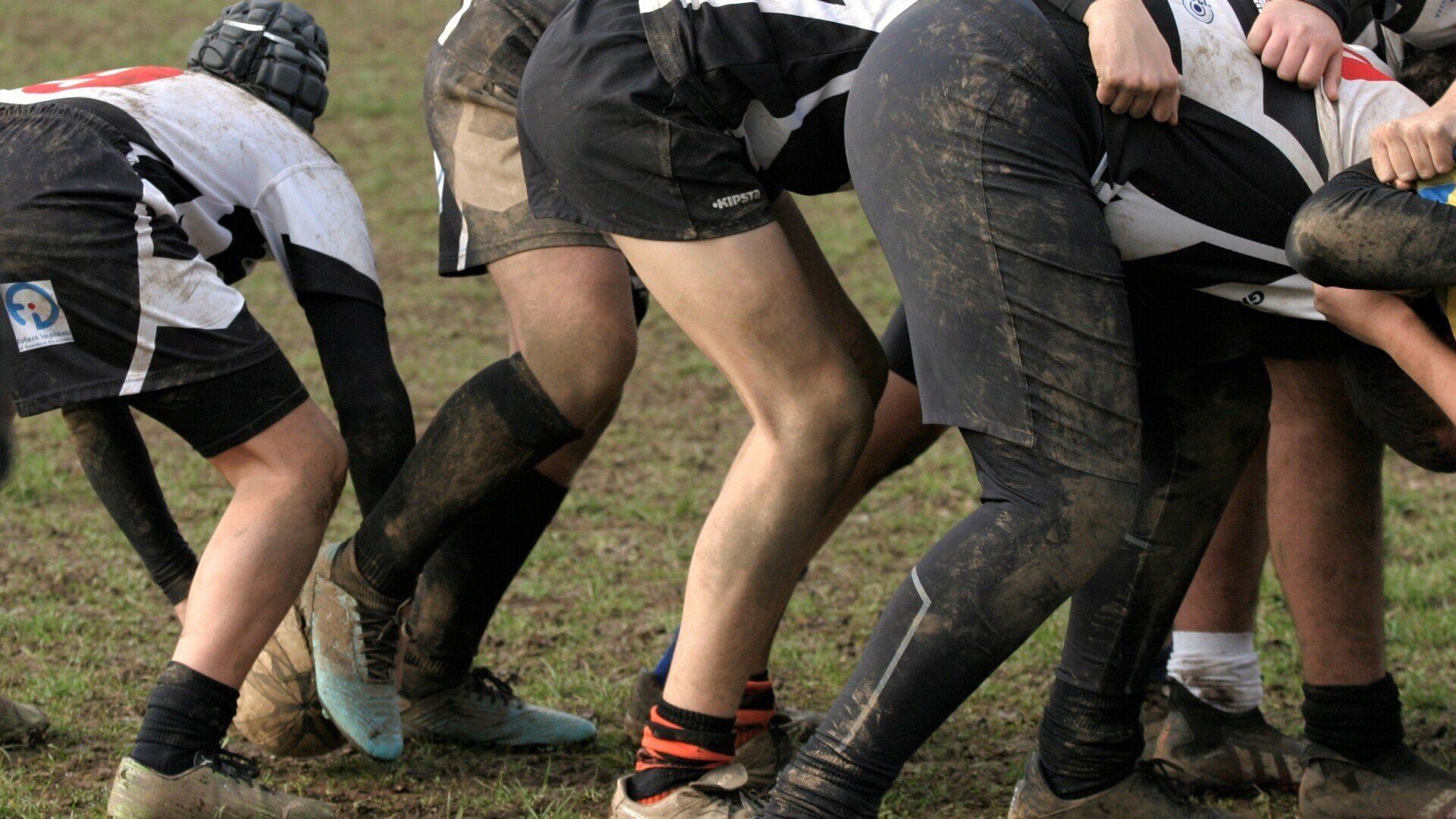 Un gruppo di persone sta giocando una partita di rugby su un campo.