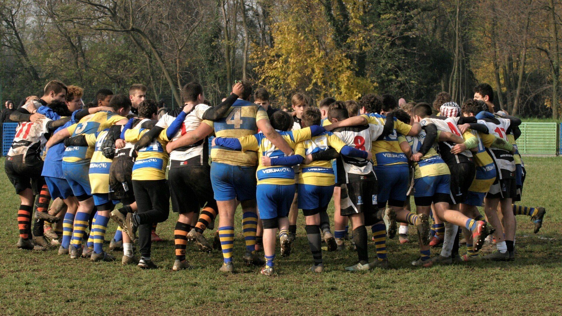 Un gruppo di giocatori di rugby sono ammassati insieme sul campo