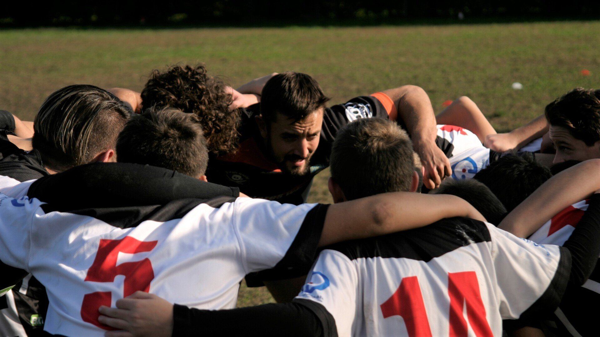 Un gruppo di giocatori di rugby sono ammassati insieme in un capannello