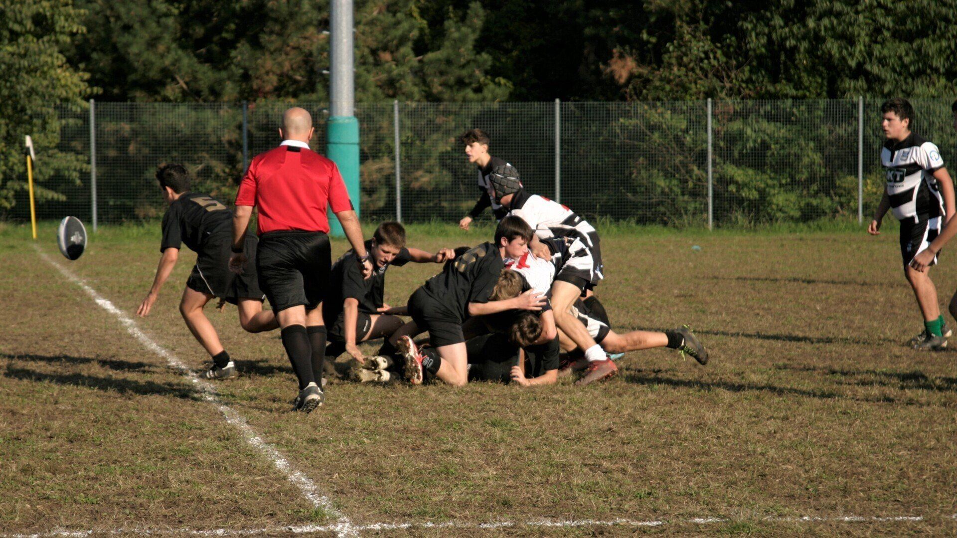 Un gruppo di giocatori di rugby sta giocando una partita su un campo