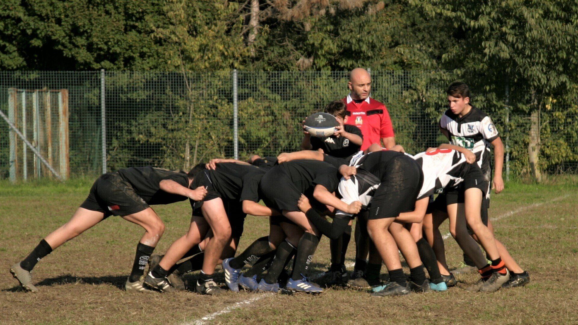 Un gruppo di giovani uomini sta giocando a rugby su un campo.