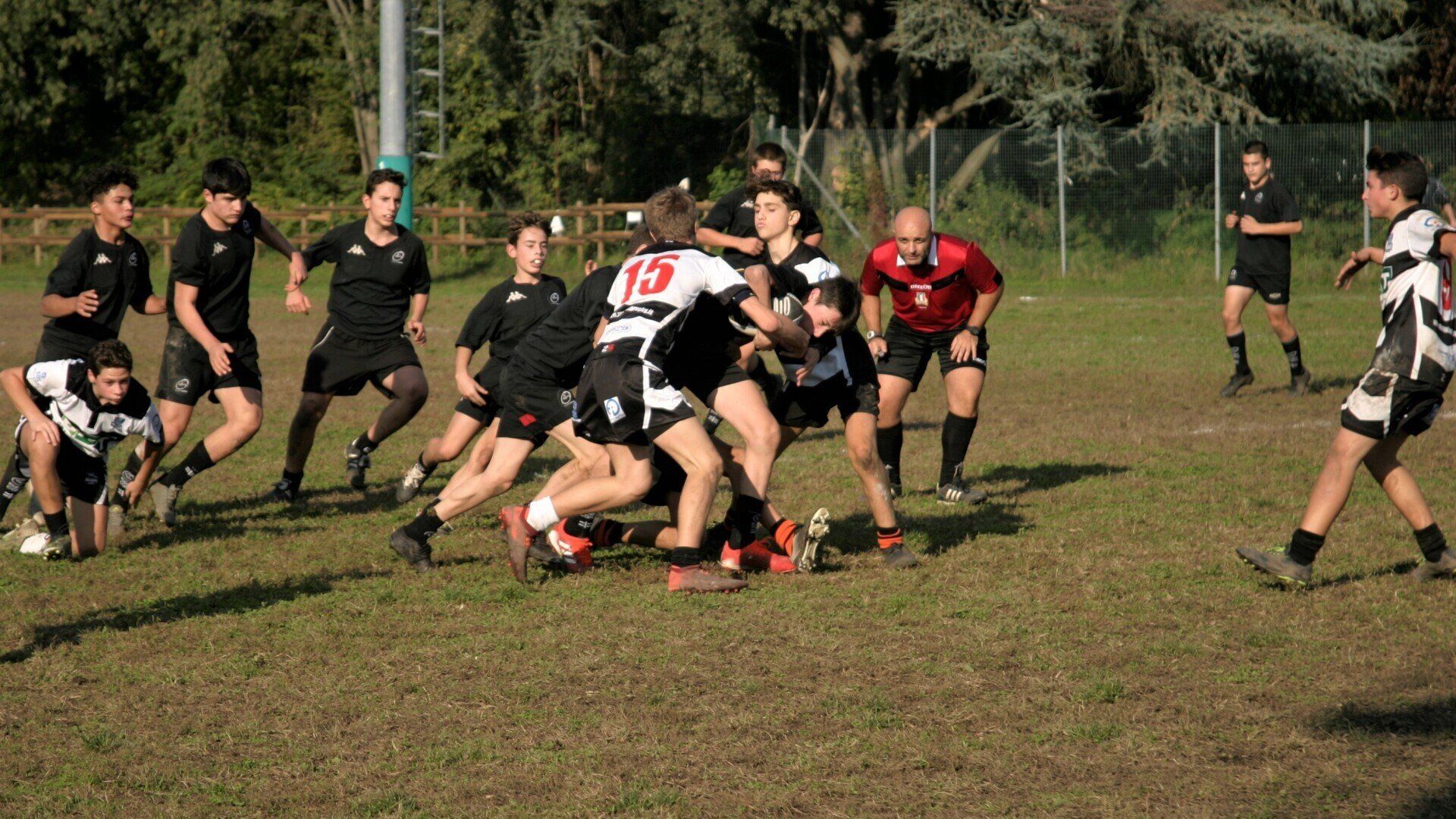 Un gruppo di giovani uomini sta giocando una partita di rugby su un campo.