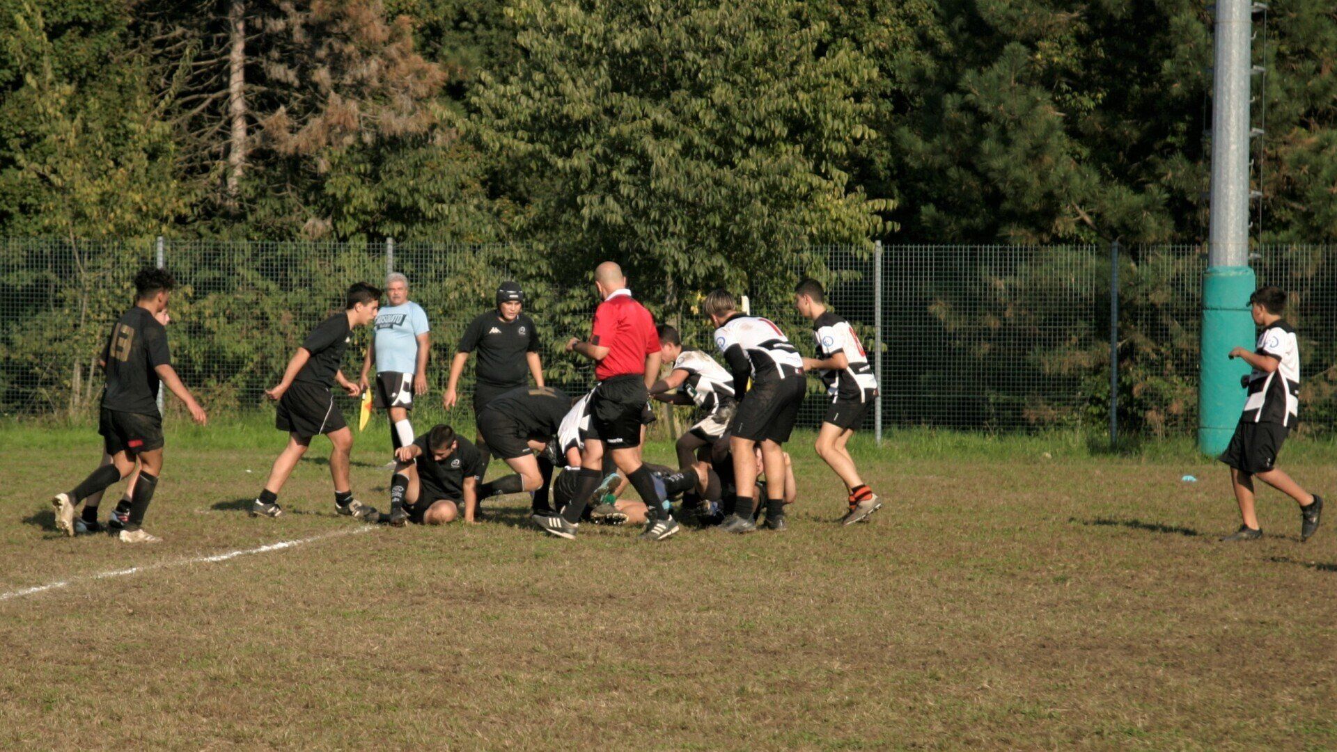 Un gruppo di giovani uomini sta giocando a rugby su un campo.