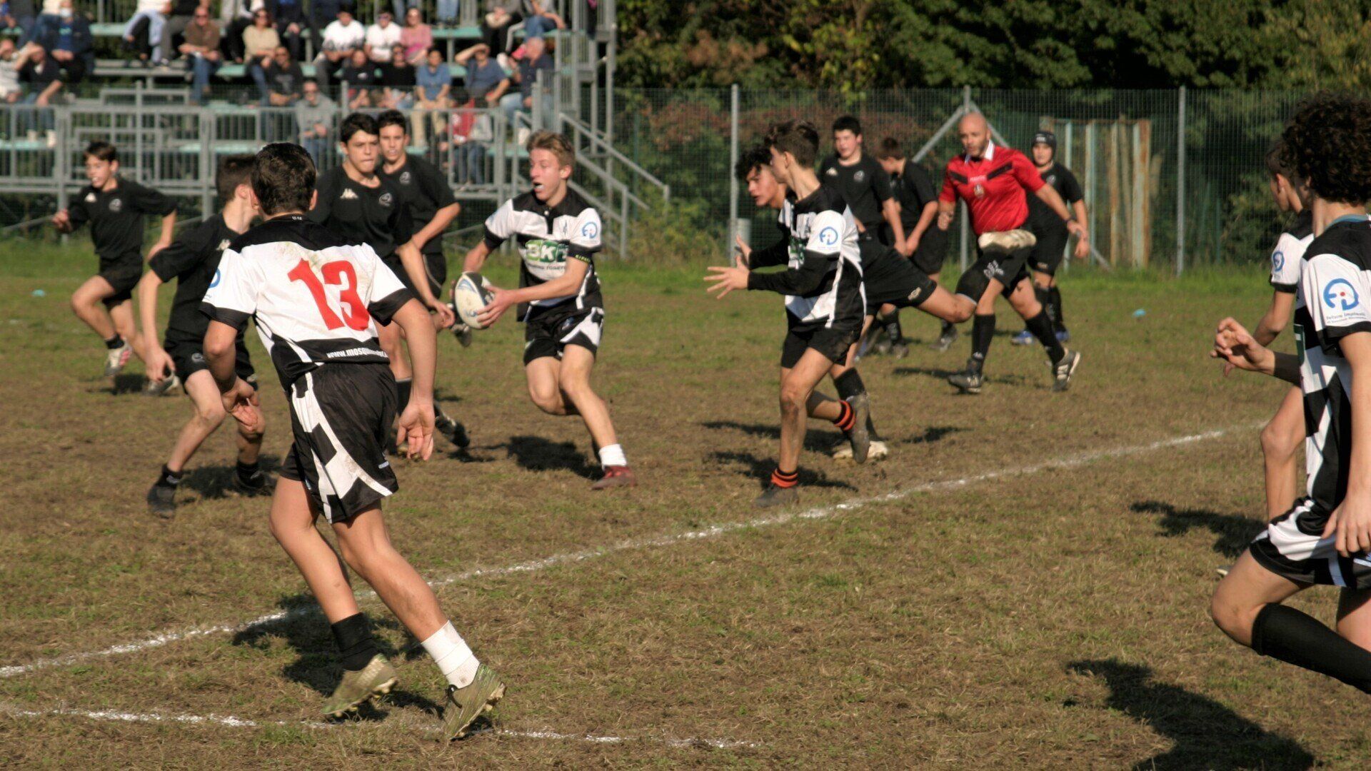 Un gruppo di giovani uomini sta giocando una partita di rugby su un campo.