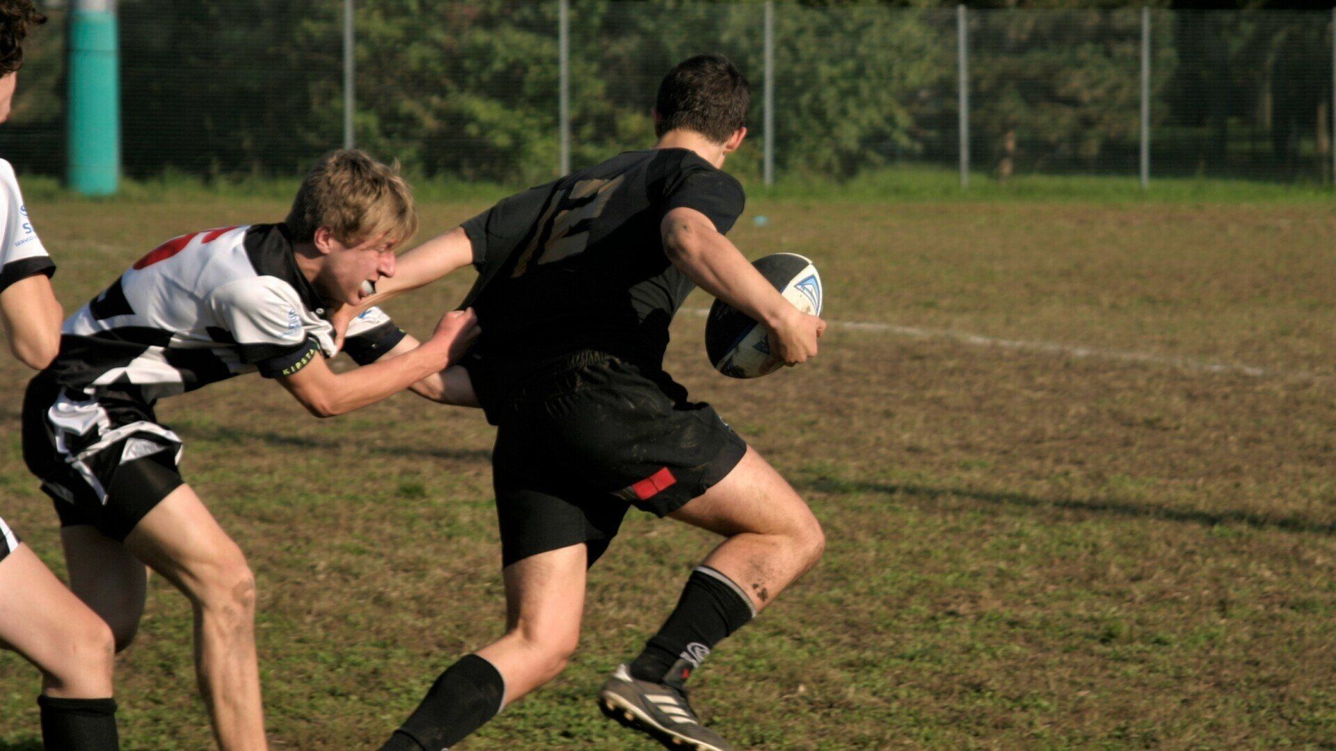 Due ragazzi stanno giocando a rugby e uno ha il numero 12 sulla maglia