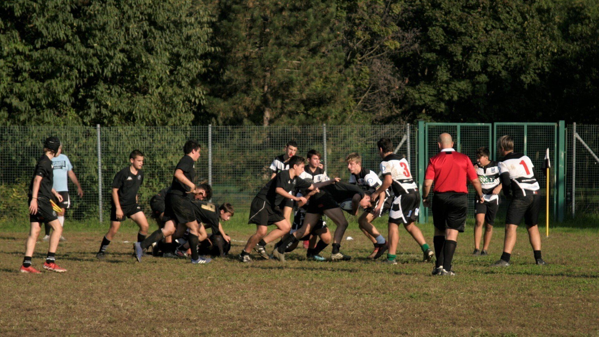 Un gruppo di giovani uomini sta giocando a rugby su un campo.