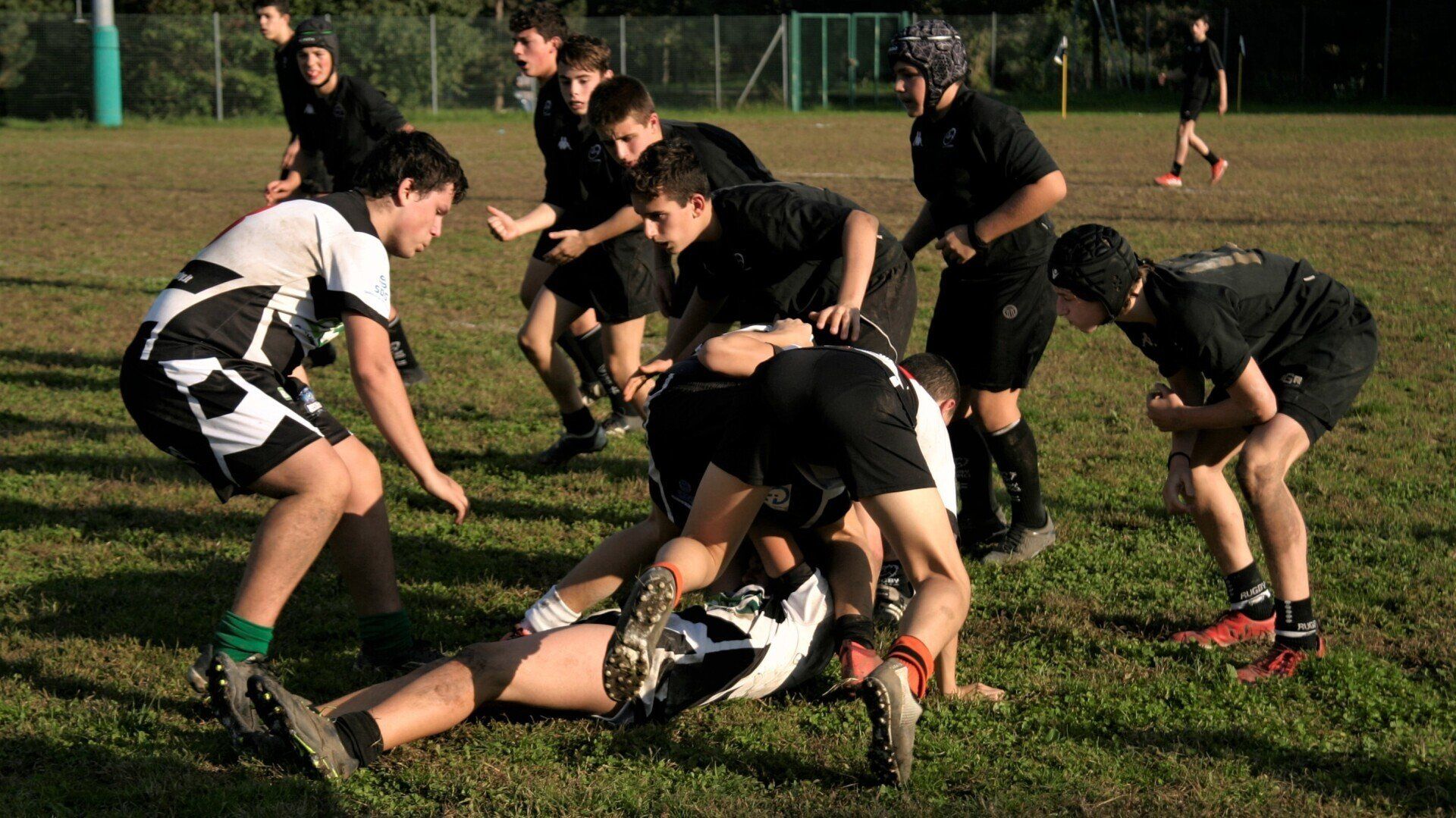 Un gruppo di giovani uomini sta giocando a rugby su un campo.