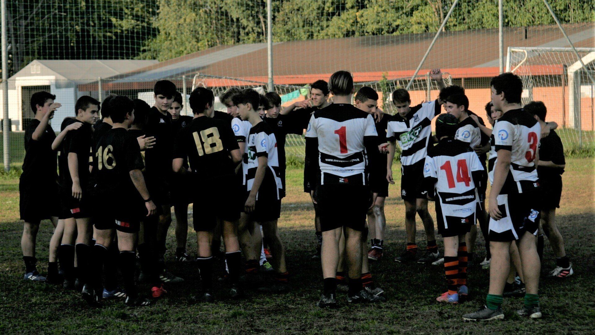 Un gruppo di giocatori di calcio è ammassato insieme in un campo.