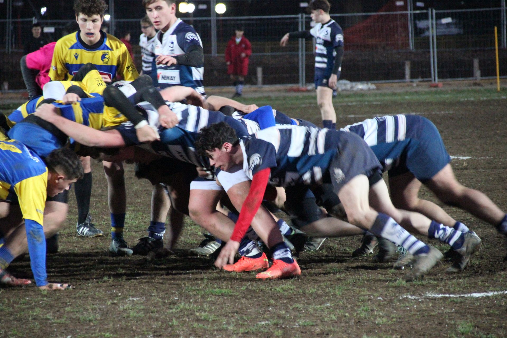 Un gruppo di giovani uomini sta giocando a rugby su un campo.