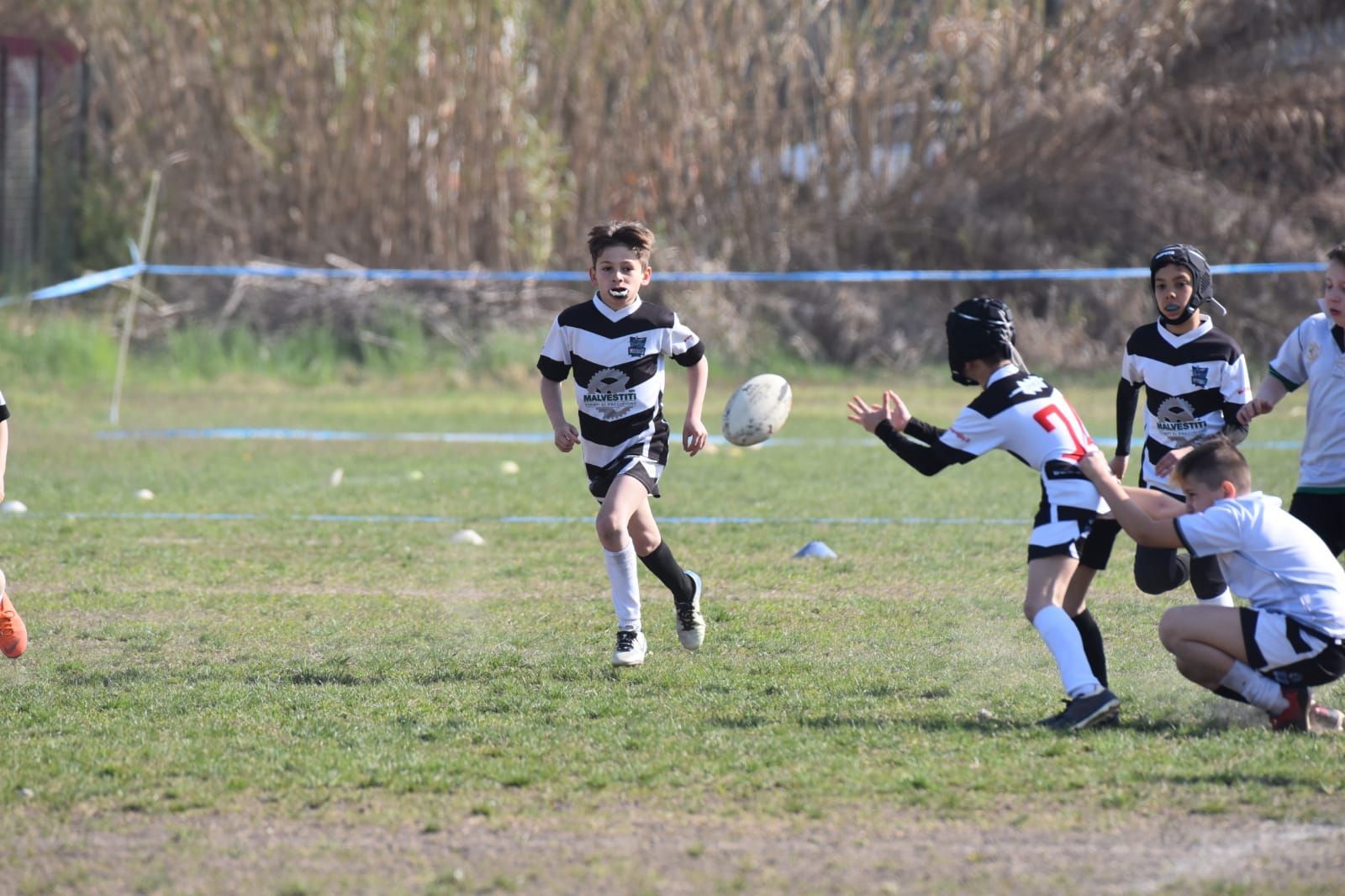 Un gruppo di ragazzi sta giocando a rugby su un campo.
