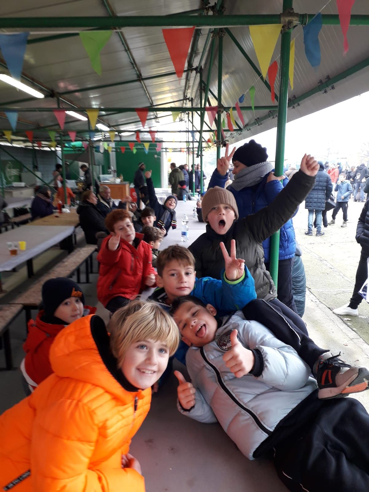 Un gruppo di bambini posa per una foto e fa il pollice in su