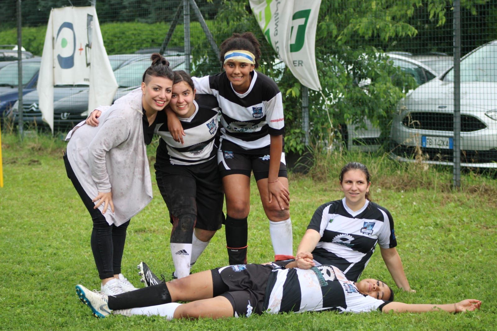 Un gruppo di donne posa per una foto su un campo da calcio.